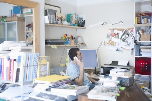 Office desk filled with papers and folders representing clutter