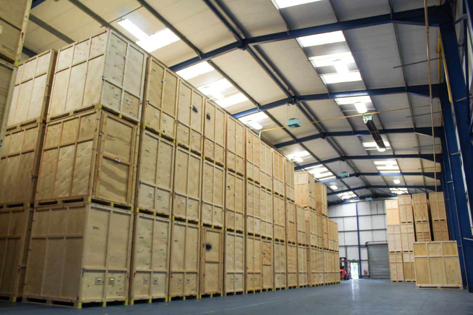 Rows of stacked wooden storage crates inside a Henfield Storage warehouse