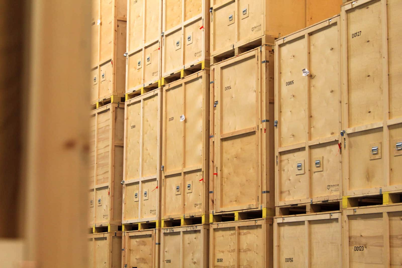 Wooden storage crates arranged in a large indoor warehouse space