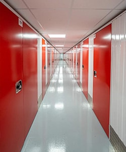 corridor of secure steel storage units with red doors