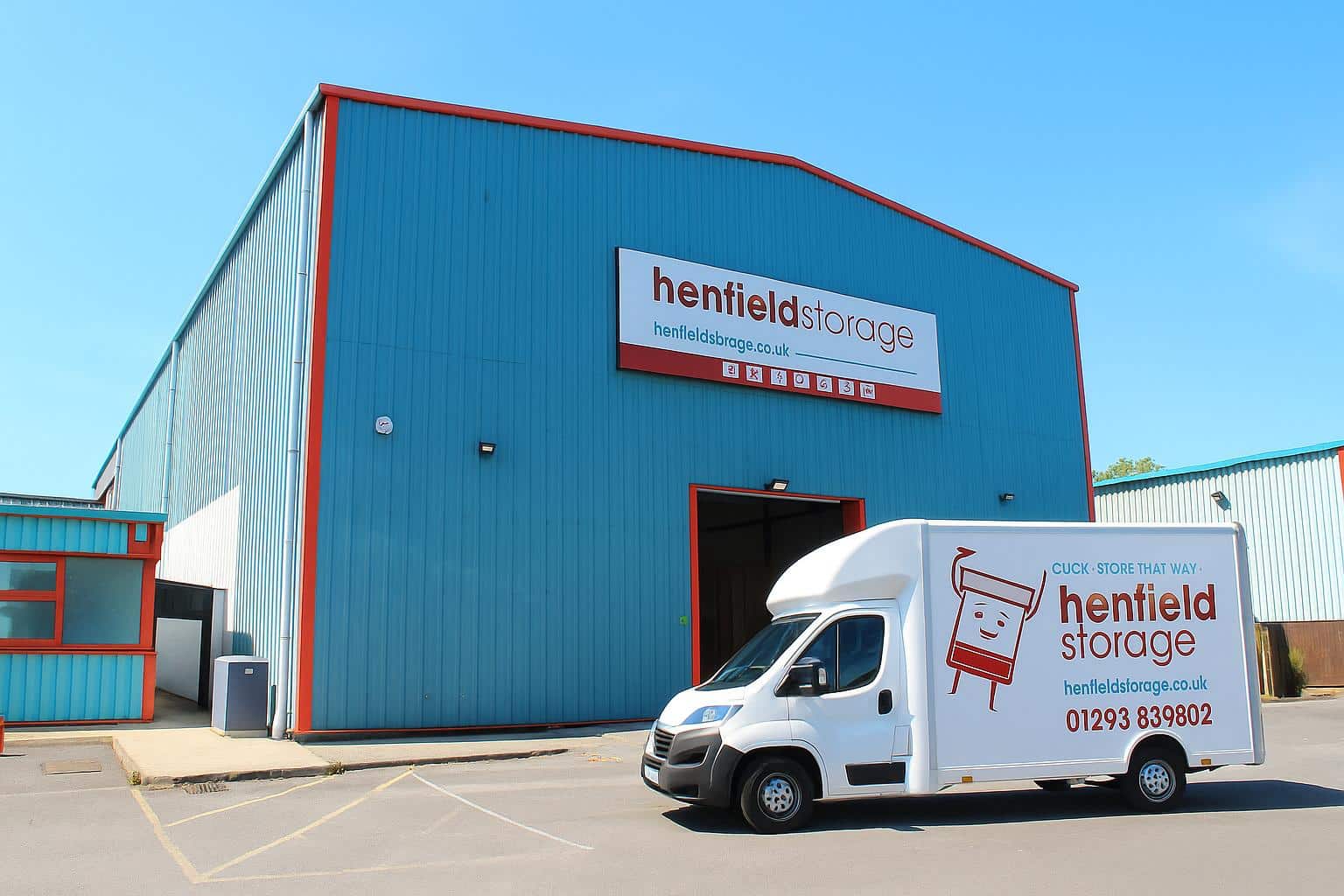 Henfield Storage warehouse exterior with branded van parked outside under clear sky