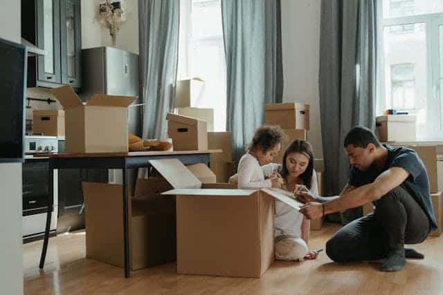 Family packing boxes together in a home during a move