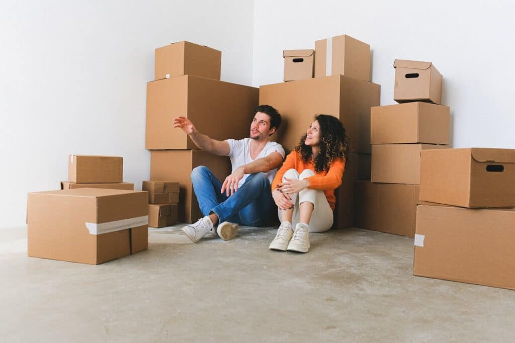 Couple sitting among moving boxes, representing personal storage needs