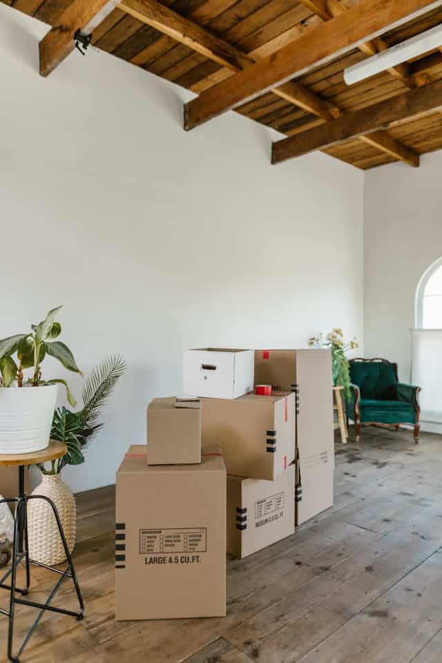 Cardboard boxes stacked in a bright, organised room after decluttering for self storage